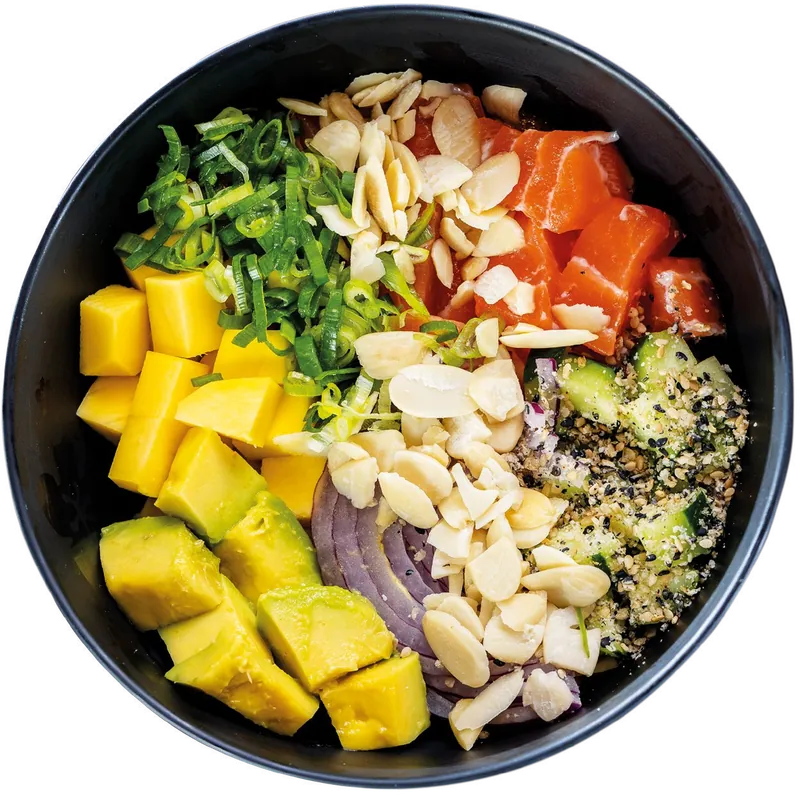 Poke Quioto: salmão, manga, avocado e lâminas de amêndoa numa tigela preta.