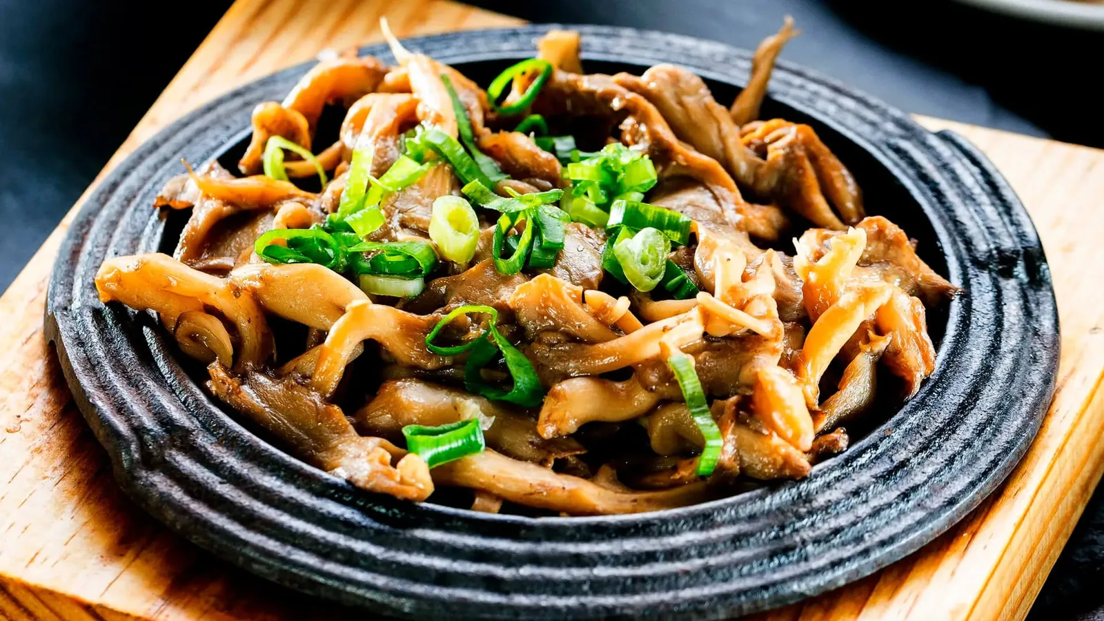 Teppanyaki de cogumelos servido na chapa de ferro fumegante.